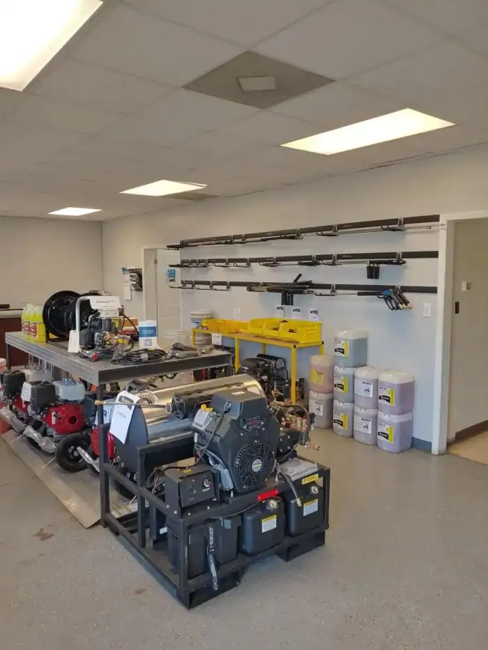 A showroom with industrial equipment and supplies, including motors, pressure washers, containers of detergent, and various tools mounted on a wall rack.